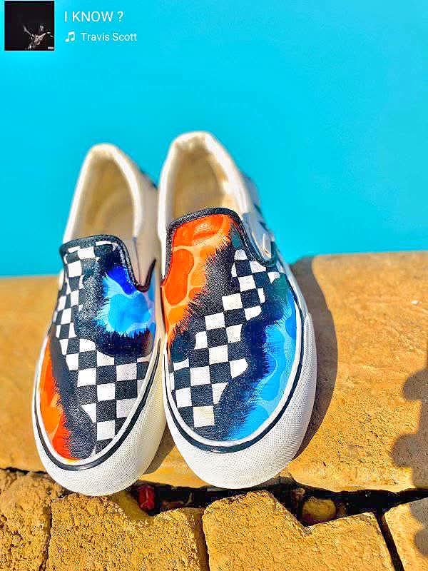 White slip-on sneakers painted with a melting checkerboard pattern in orange, navy and blue